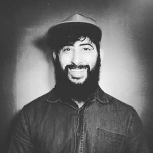 Roger Ramos grayscale profile photo with a nice smile and hat